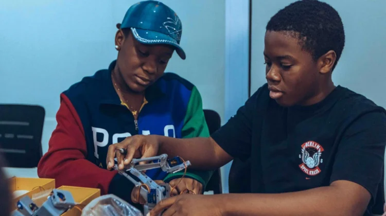 Two students assembling a robot in a hands-on STEM workshop in Accra, Ghana.