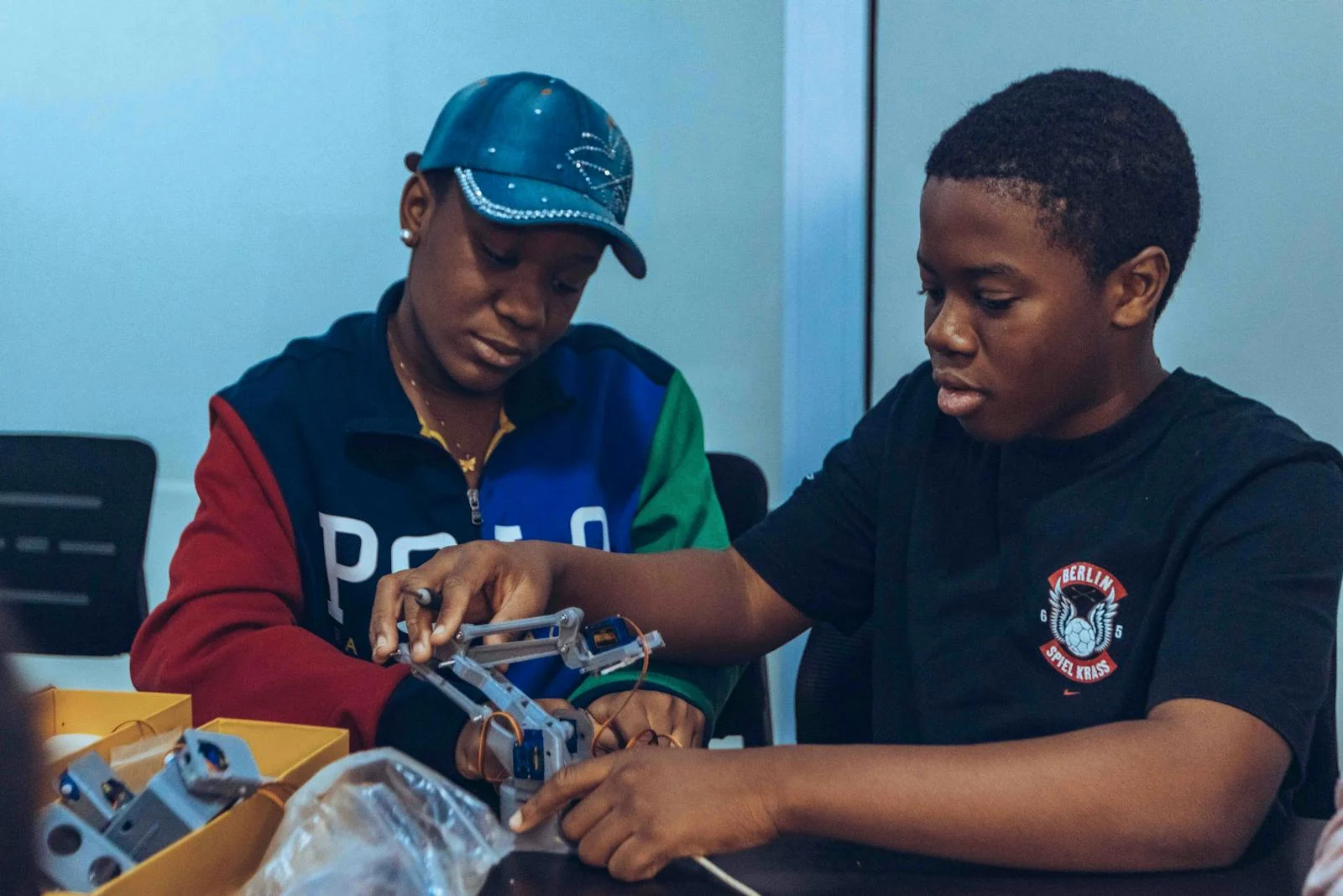 Two students assembling a robot in a hands-on STEM workshop in Accra, Ghana.