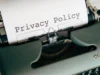 Close-up of a vintage typewriter featuring a privacy policy document in focus, highlighting classic technology.