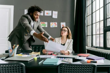 Colleagues in a lively discussion during a team meeting in a modern office space.