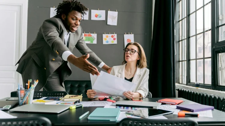 Colleagues in a lively discussion during a team meeting in a modern office space.
