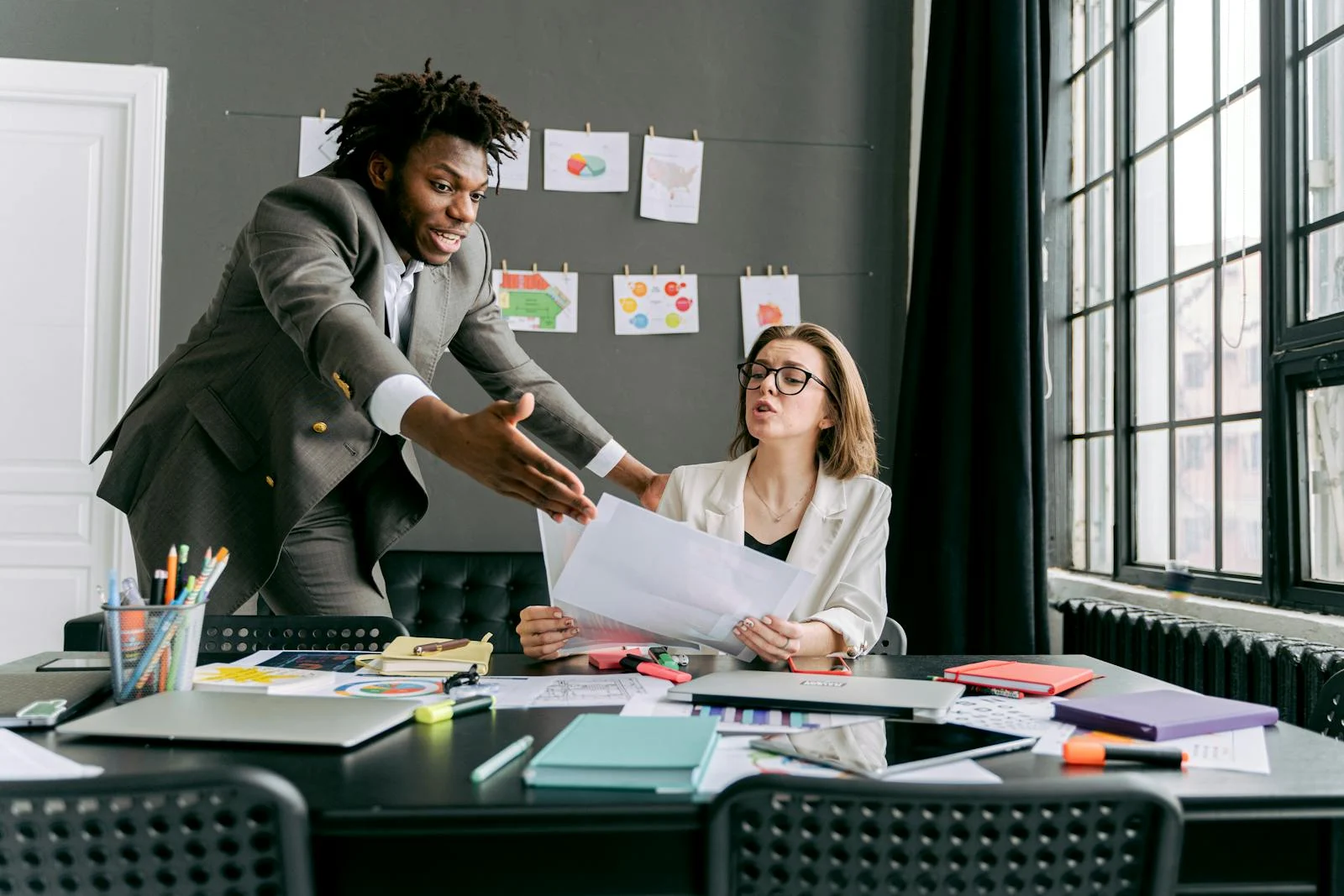 Colleagues in a lively discussion during a team meeting in a modern office space.