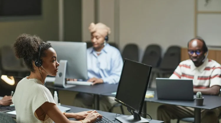 Three call center agents at work, focused and professional in a modern office environment.