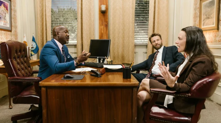 Three attorneys in a legal discussion at a well-appointed law office.