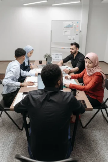 A diverse team of adults collaborating in an office meeting room.