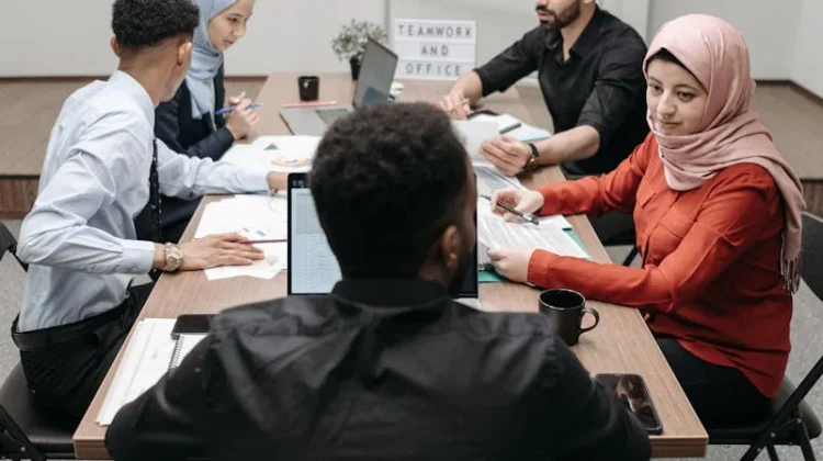 A diverse team of adults collaborating in an office meeting room.
